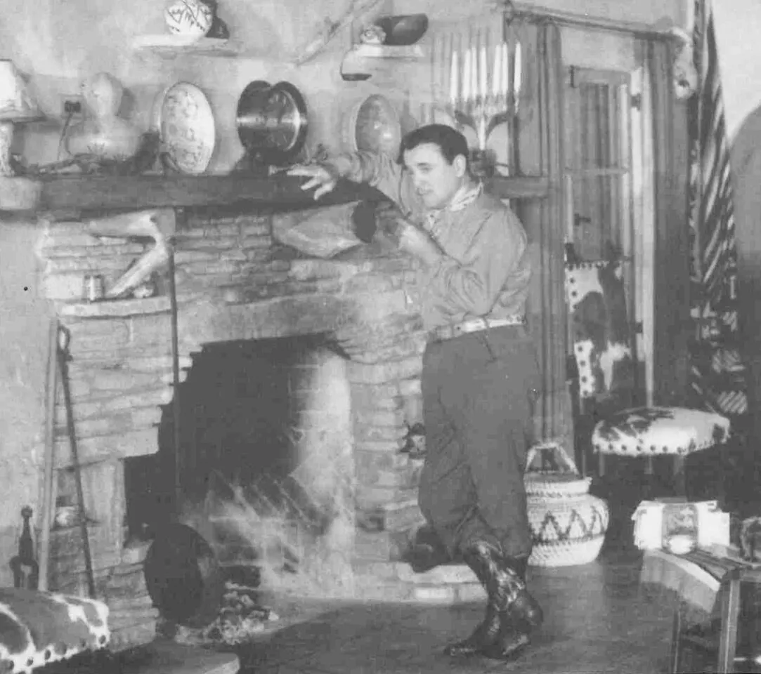 Leo Carrillo standing by the stone fireplace at his Los Alisos ranch in Santa Monica Canyon