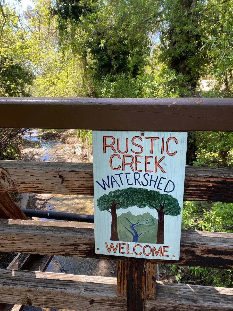 Hand-painted Rustic Creek Watershed welcome sign at the canyon trail entrance