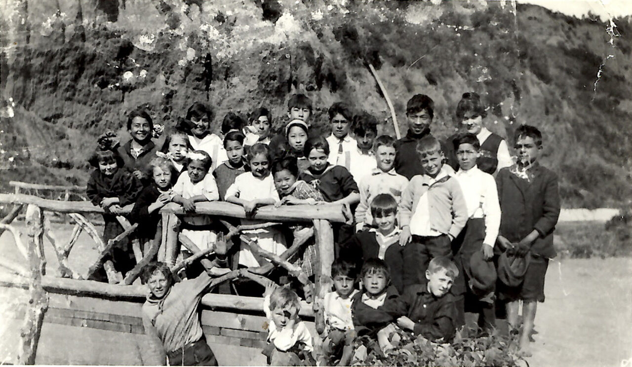 Group of approximately thirty Santa Monica Canyon schoolchildren posed on a wooden fence, early 1900s