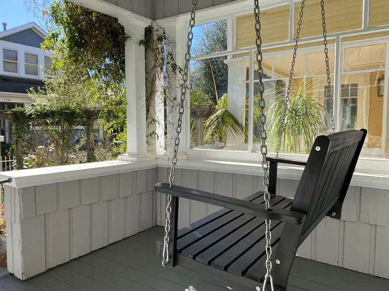 Classic porch swing on a craftsman-style Venice home with views of the neighborhood